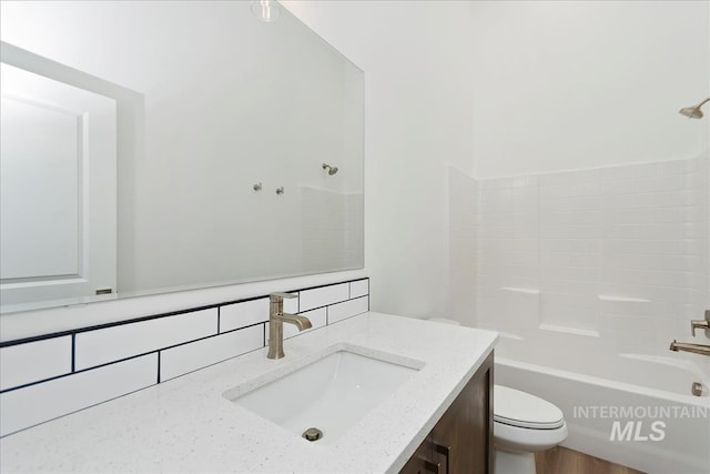 full bathroom with vanity, bathing tub / shower combination, backsplash, and toilet