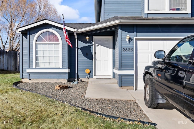 doorway to property with a garage, roof with shingles, and fence