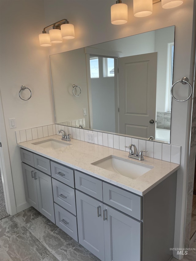 bathroom with double vanity, a sink, and marble finish floor