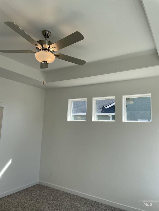 carpeted empty room featuring baseboards and ceiling fan