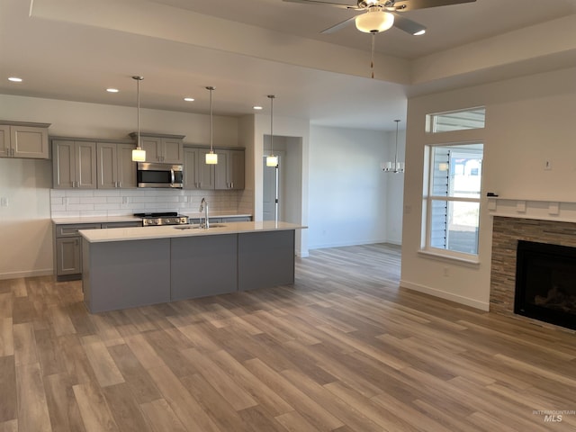 kitchen with a sink, stainless steel microwave, and gray cabinetry