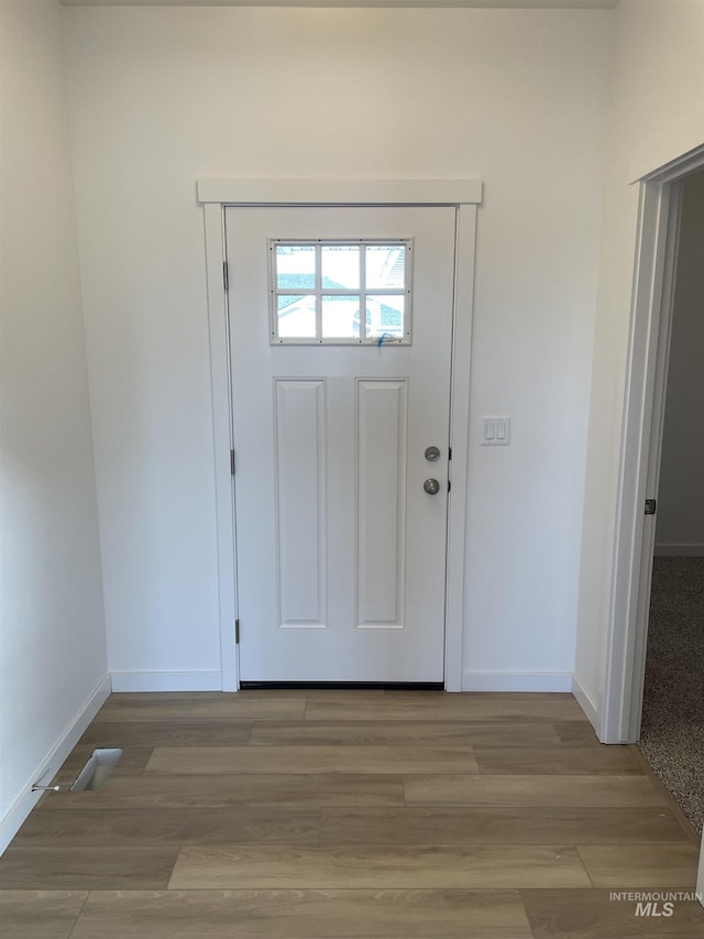 entrance foyer with baseboards and wood finished floors