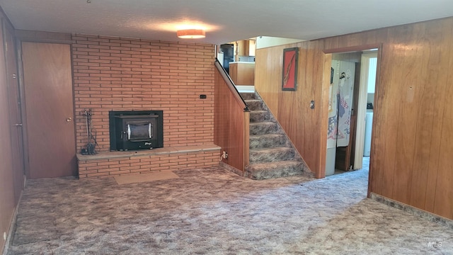 17 W 208 S, Burley, ID 83318 - unfurnished living room with stairway, wooden walls, carpet flooring, and a wood stove