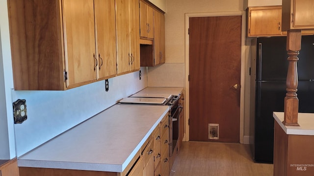 17 W 208 S, Burley, ID 83318 - kitchen with gas range, freestanding refrigerator, light countertops, and brown cabinetry