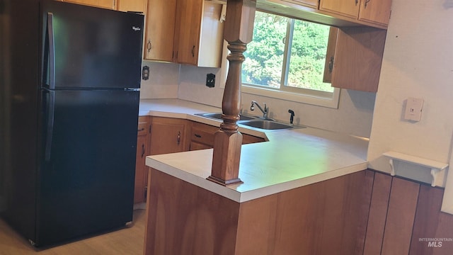 17 W 208 S, Burley, ID 83318 - kitchen featuring freestanding refrigerator, light countertops, a peninsula, a sink, and brown cabinets