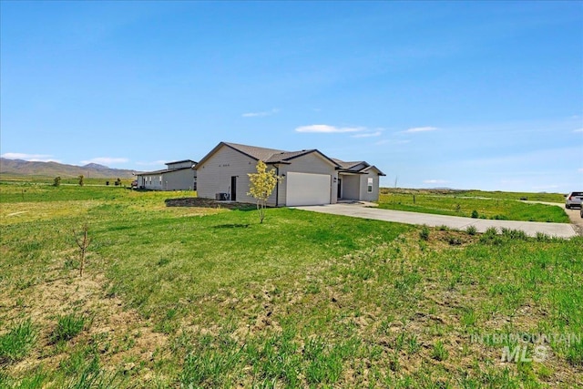 190 Bison Way, Fairfield, ID 83327 - view of side of home with driveway, an attached garage, a yard, a view of countryside, and a mountain view