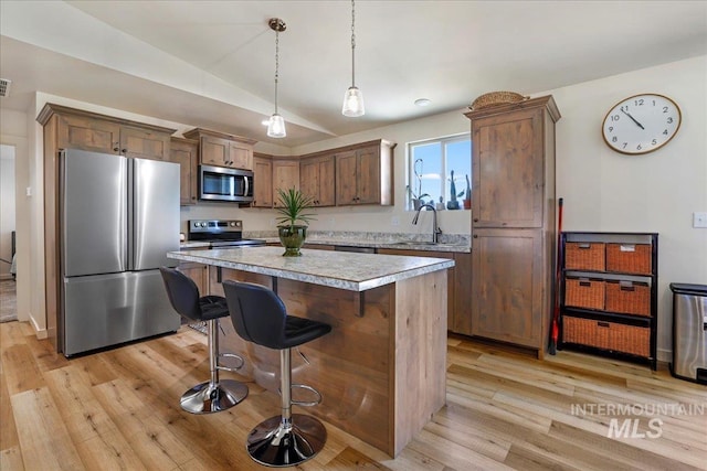 190 Bison Way, Fairfield, ID 83327 - kitchen featuring appliances with stainless steel finishes, light wood finished floors, a center island, a kitchen breakfast bar, and vaulted ceiling
