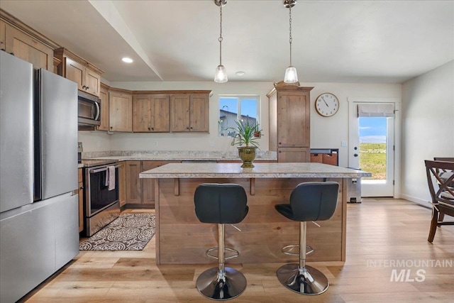 190 Bison Way, Fairfield, ID 83327 - kitchen featuring appliances with stainless steel finishes, light wood finished floors, a kitchen bar, healthy amount of natural light, and recessed lighting