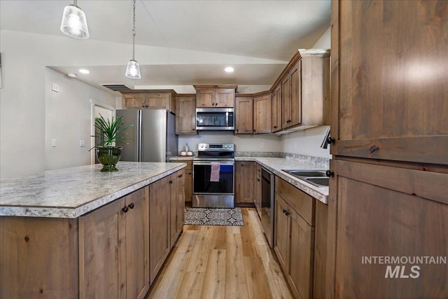 190 Bison Way, Fairfield, ID 83327 - kitchen featuring stainless steel appliances, light wood-type flooring, vaulted ceiling, decorative light fixtures, and light countertops