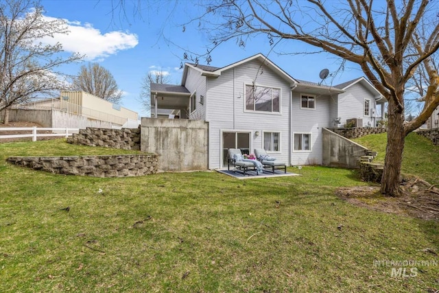 rear view of house with a lawn and a patio