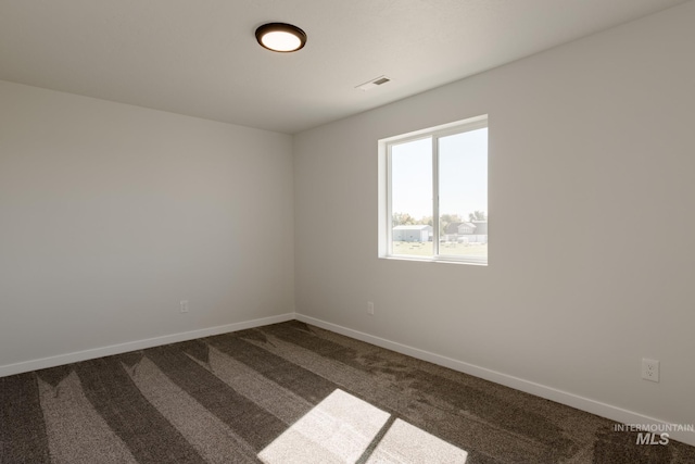 empty room featuring carpet floors, stairway, visible vents, and baseboards