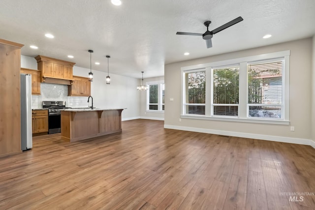 74 E Ranch Dr, Eagle, ID 83616 - kitchen with appliances with stainless steel finishes, light wood-style flooring, a ceiling fan, recessed lighting, and decorative backsplash