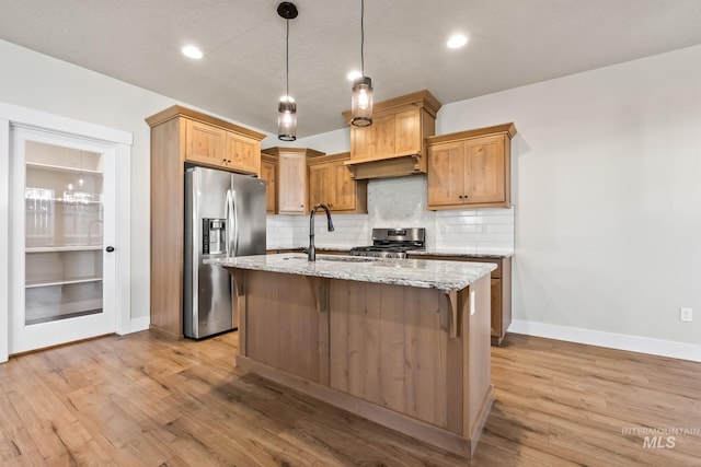74 E Ranch Dr, Eagle, ID 83616 - kitchen featuring stainless steel appliances, backsplash, light wood-type flooring, light stone counters, and range hood