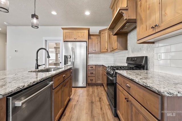 74 E Ranch Dr, Eagle, ID 83616 - kitchen with stainless steel appliances, exhaust hood, light wood-type flooring, light stone countertops, and recessed lighting