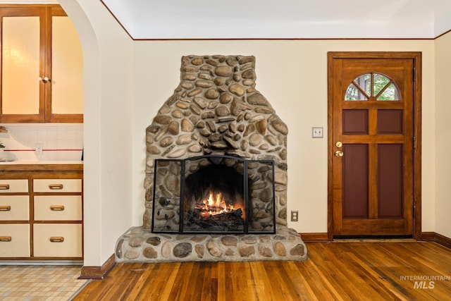 interior space featuring a stone fireplace and wood-type flooring