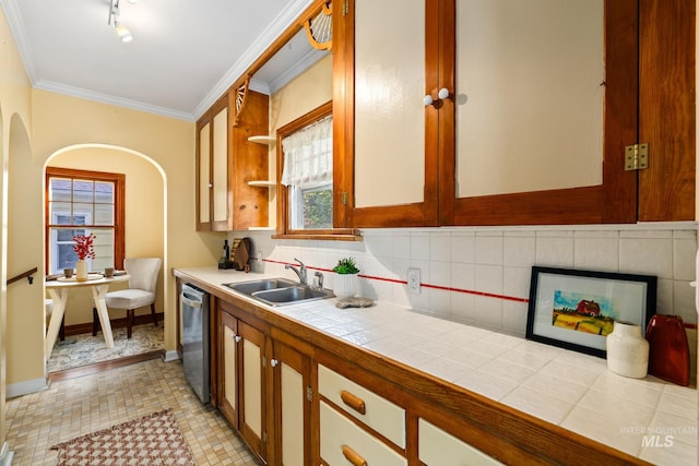 kitchen with stainless steel dishwasher, sink, tile counters, decorative backsplash, and light tile patterned floors