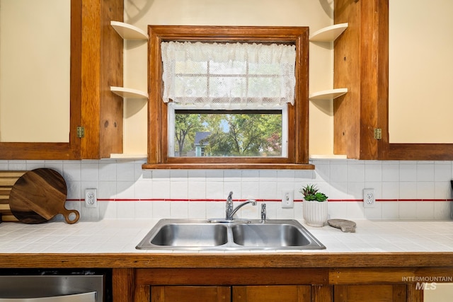 kitchen with tile counters, sink, and tasteful backsplash