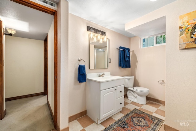 bathroom with vanity, a shower with shower door, and toilet