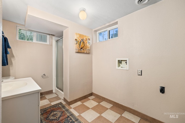 bathroom featuring vanity, walk in shower, and a textured ceiling