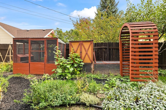 view of yard with a sunroom and a storage shed