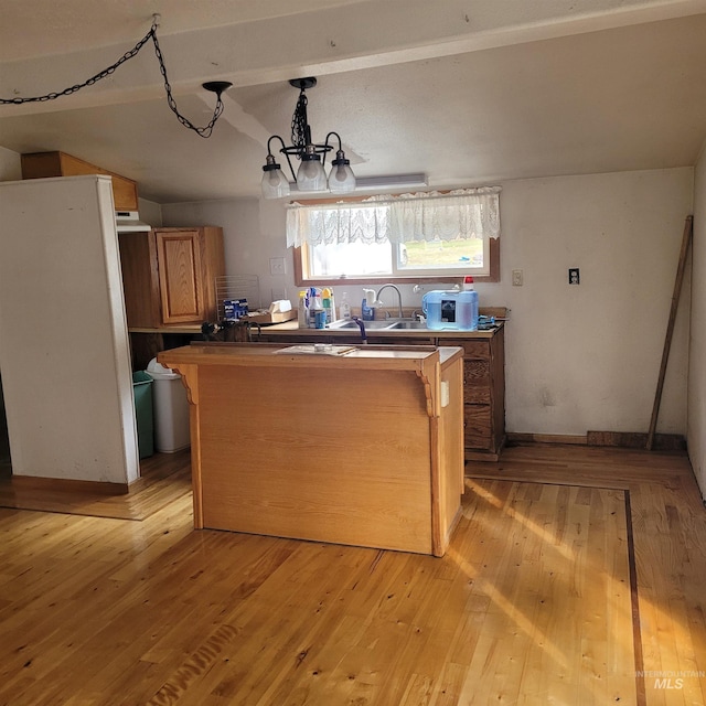 kitchen featuring an inviting chandelier, baseboards, light wood-style floors, and a sink