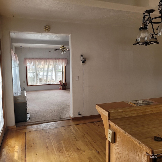 interior space with light wood-style floors, baseboards, and a textured ceiling