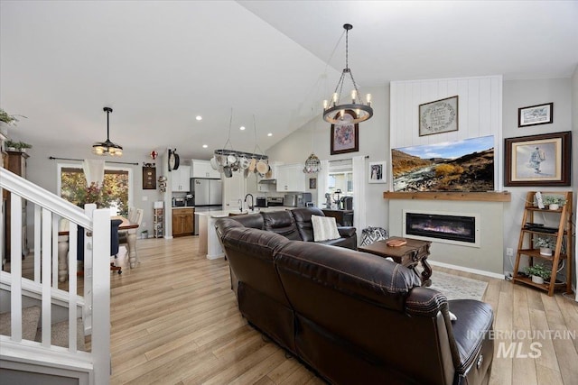 1440 Riverbend Pl, Twin Falls, ID 83301 - living area featuring a chandelier, a glass covered fireplace, light wood-style flooring, stairway, and recessed lighting