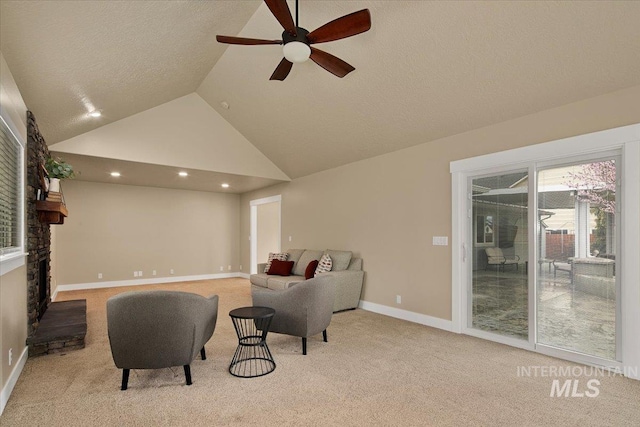 living area with high vaulted ceiling, a textured ceiling, a ceiling fan, carpet flooring, and baseboards