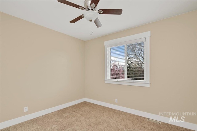 spare room featuring visible vents, light colored carpet, and baseboards