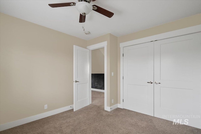 unfurnished bedroom featuring ceiling fan, a closet, baseboards, and carpet floors