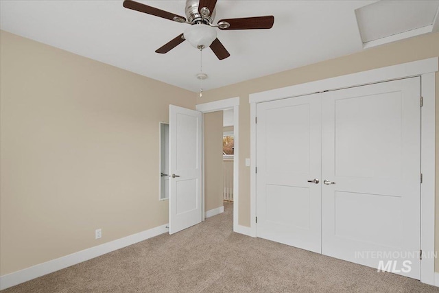 unfurnished bedroom with light carpet, a closet, ceiling fan, and baseboards