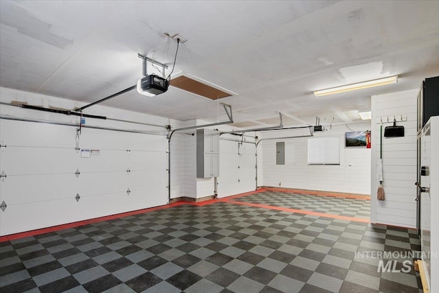 garage with a garage door opener and electric panel
