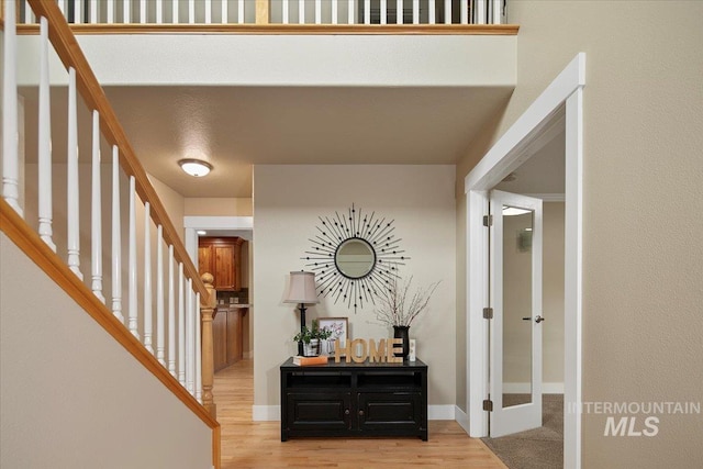 interior space with baseboards, stairway, and wood finished floors