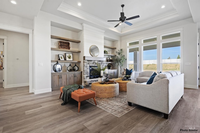 3053 Ajax Ave, Eagle, ID 83616 - living area with a raised ceiling, light wood-style flooring, ornamental molding, ceiling fan, and a stone fireplace