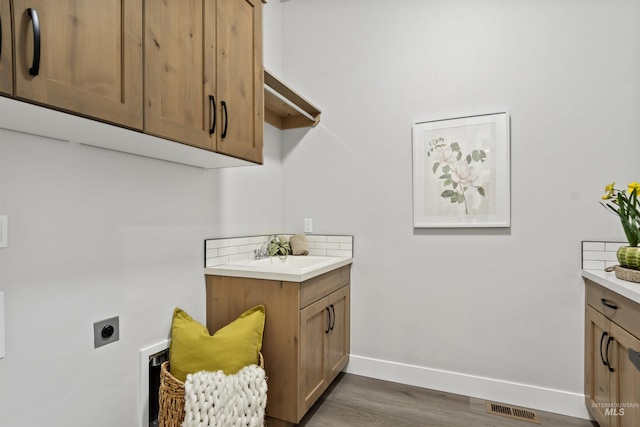 3053 Ajax Ave, Eagle, ID 83616 - washroom with electric dryer hookup, baseboards, dark wood-type flooring, and cabinet space