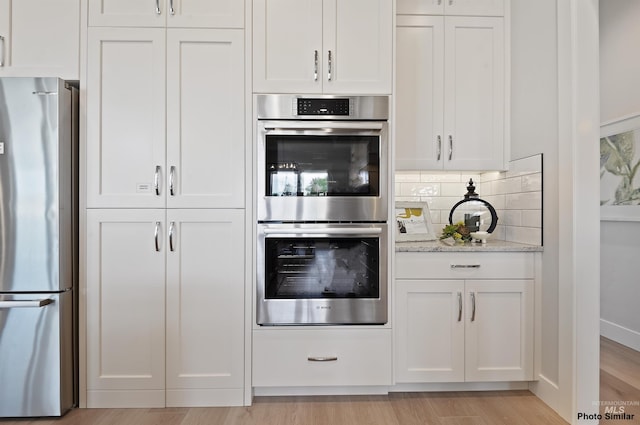 3053 Ajax Ave, Eagle, ID 83616 - kitchen with appliances with stainless steel finishes, light wood-type flooring, and white cabinetry