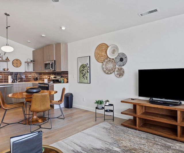 1681 W Idaho St, Boise, ID 83702 - living area featuring baseboards, light wood finished floors, vaulted ceiling, and visible vents