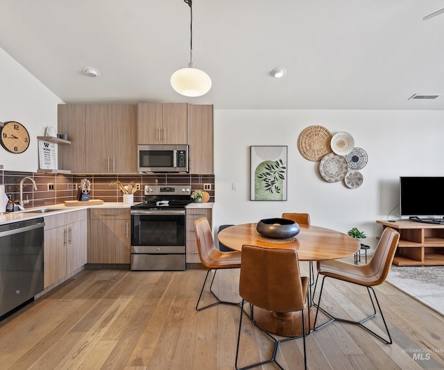 1681 W Idaho St, Boise, ID 83702 - kitchen featuring open shelves, light countertops, a sink, light wood-style flooring, and appliances with stainless steel finishes