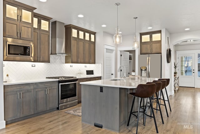 486 E Andes Dr, Kuna, ID 83634 - kitchen with wall chimney exhaust hood, a sink, light countertops, stainless steel appliances, and light wood-style flooring
