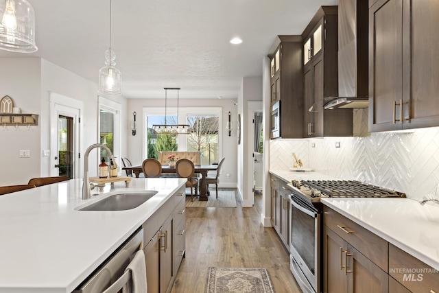 486 E Andes Dr, Kuna, ID 83634 - kitchen with light countertops, a sink, wall chimney range hood, and stainless steel appliances