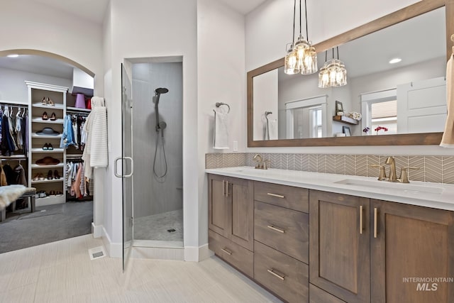 486 E Andes Dr, Kuna, ID 83634 - full bathroom featuring a stall shower, decorative backsplash, a sink, and a walk in closet