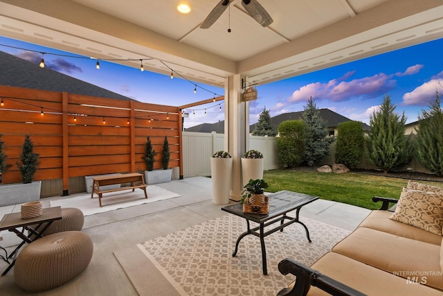 486 E Andes Dr, Kuna, ID 83634 - patio terrace at dusk featuring a fenced backyard, a ceiling fan, a lawn, and outdoor lounge area
