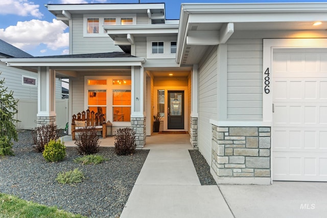 486 E Andes Dr, Kuna, ID 83634 - doorway to property featuring covered porch, a garage, and stone siding