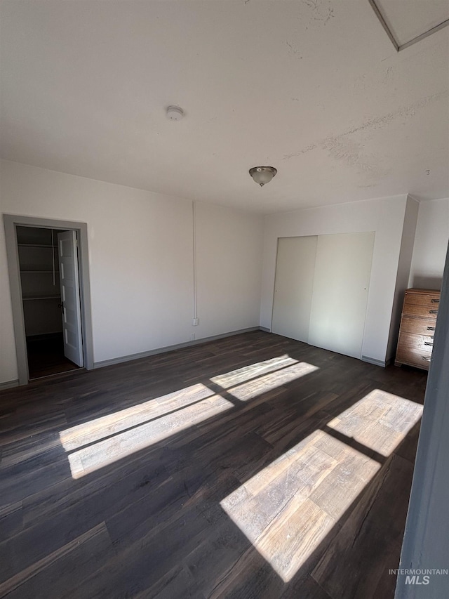 157 N 4th E, St, Mountain Home, ID 83647 - unfurnished bedroom with dark wood-type flooring, baseboards, and a closet