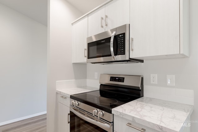 310 Chalcedony Ave, Caldwell, ID 83605 - kitchen featuring white cabinets, light wood-style floors, appliances with stainless steel finishes, and baseboards