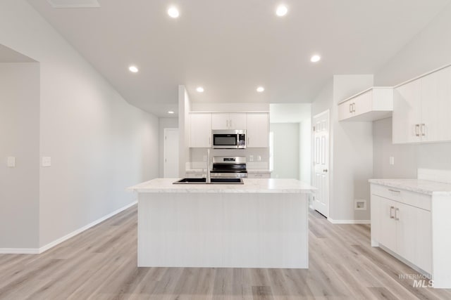 310 Chalcedony Ave, Caldwell, ID 83605 - kitchen featuring light countertops, light wood-style floors, stainless steel appliances, and an island with sink