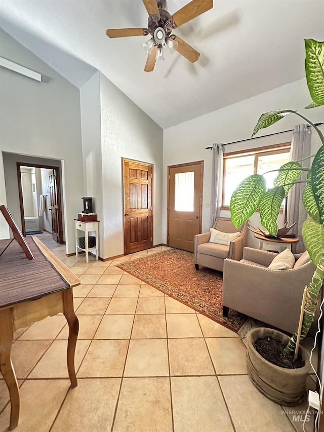 foyer with lofted ceiling, light tile patterned floors, and a ceiling fan