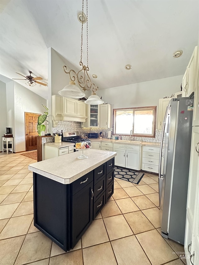 kitchen with dark cabinetry, light tile patterned floors, light countertops, and stainless steel appliances