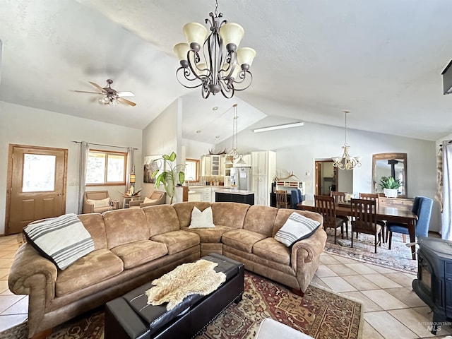 living area featuring light tile patterned flooring, ceiling fan with notable chandelier, a wood stove, and lofted ceiling