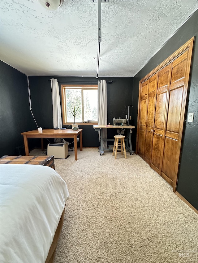 bedroom featuring a closet, a textured ceiling, and carpet floors